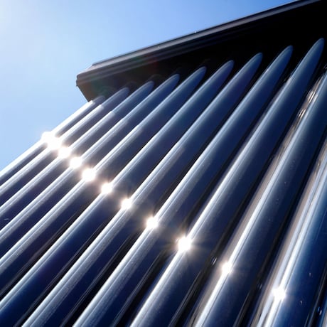 Gros plan sur un capteur solaire thermique tubulaire en plein soleil, rayons du soleil réfléchis sur les tubes. Gros plan sur un capteur solaire thermique tubulaire en plein soleil, rayons du soleil réfléchis sur les tubes.