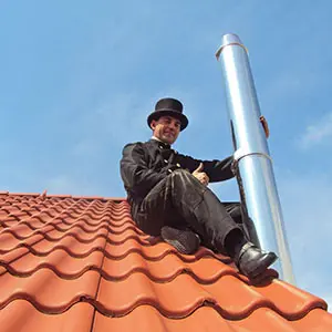 Schornsteinfeger mit Edelstahlschornstein auf dem Dach
