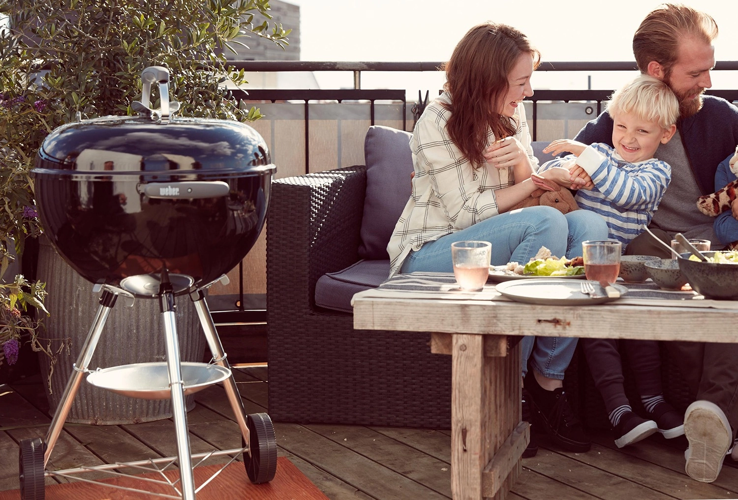 Weber Bar-B-Kettle auf einem Balkon mit einer Familie