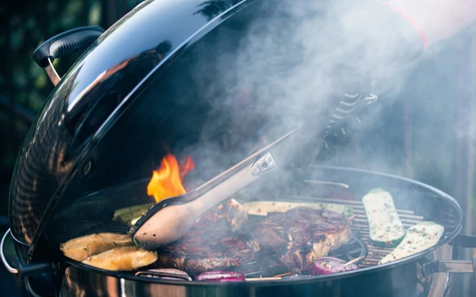 Weber Kugelgrill in Aktion mit voll belegtem Grillrost