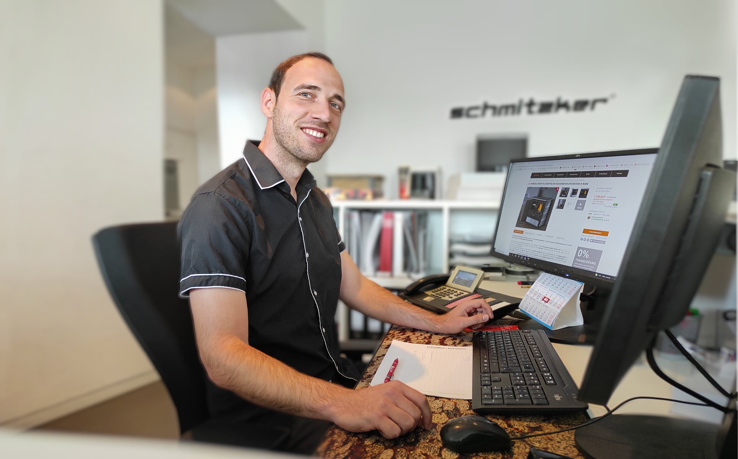 kamdi24-Mitarbeiter an seinem Arbeitsplatz mit Bildschirm und Tastatur