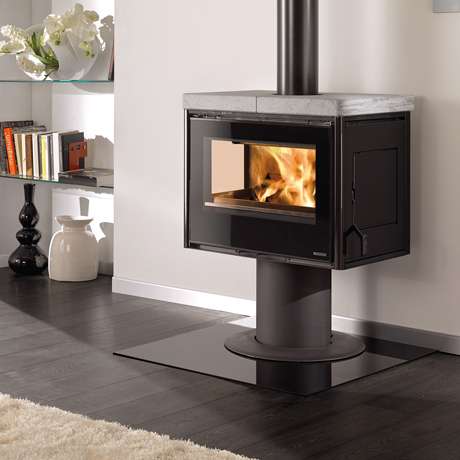 Ein schwarzer Holzofen mit einer großen Glasscheibe in einem modernen Wohnzimmer. Ein schwarzer Holzofen mit einer großen Glasscheibe in einem modernen Wohnzimmer.