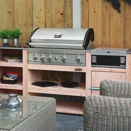 Den Grandhall Elite G4 Einbau-Gasgrill in einem Garten mit Holzoptik Den Grandhall Elite G4 Einbau-Gasgrill in einem Garten mit Holzoptik